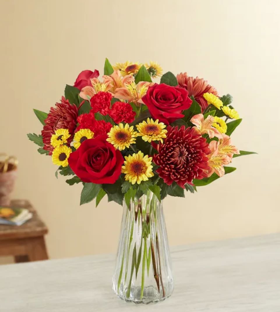Fall Enchantment Bouquet - A crispness in the air. A landscape alive with color. Our bouquet celebrates fall’s magic in radiant style. A mix of red and orange blooms with warm hints of copper and bronze, it’s the perfect way to share autumn’s enchantment with the people you care about.