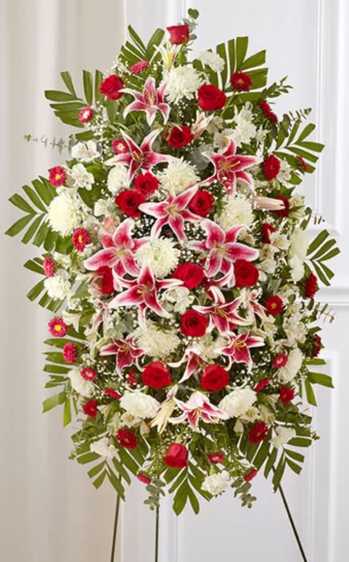 Red Rose And Lily Standing Spray - Red &amp; White Sympathy Standing Spray Celebrate a beautiful life with a truly heartfelt gesture. Our elegant standing sympathy spray is arranged with a gathering of radiant red, soft pink and pure white blooms. A traditional floral display for the services, it’s a touching way to honor the memory of a loved one while expressing your deepest condolences.