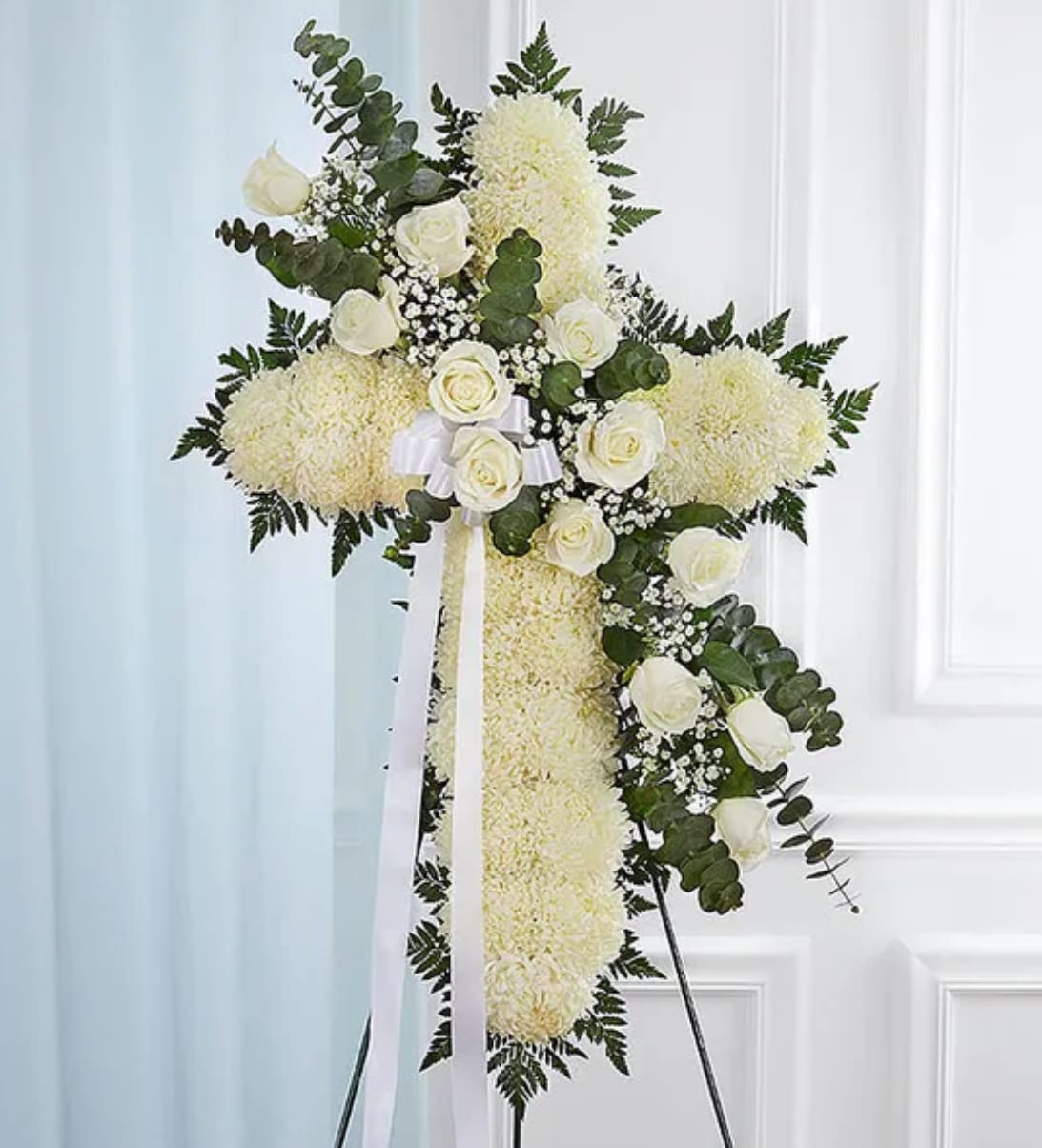 White floral standing cross with roses and ribbon