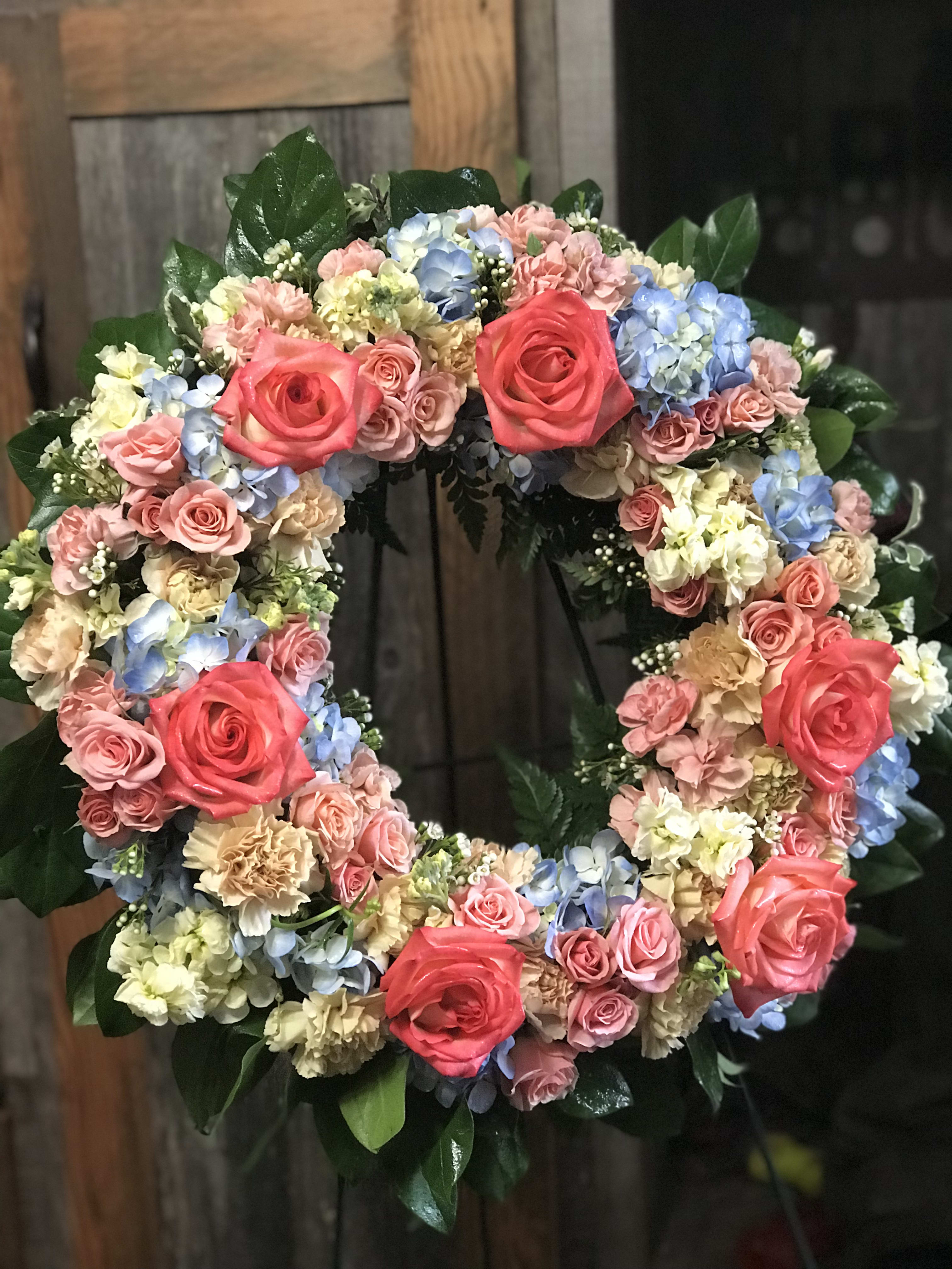 Circular floral wreath with pink roses and pastel hydrangeas