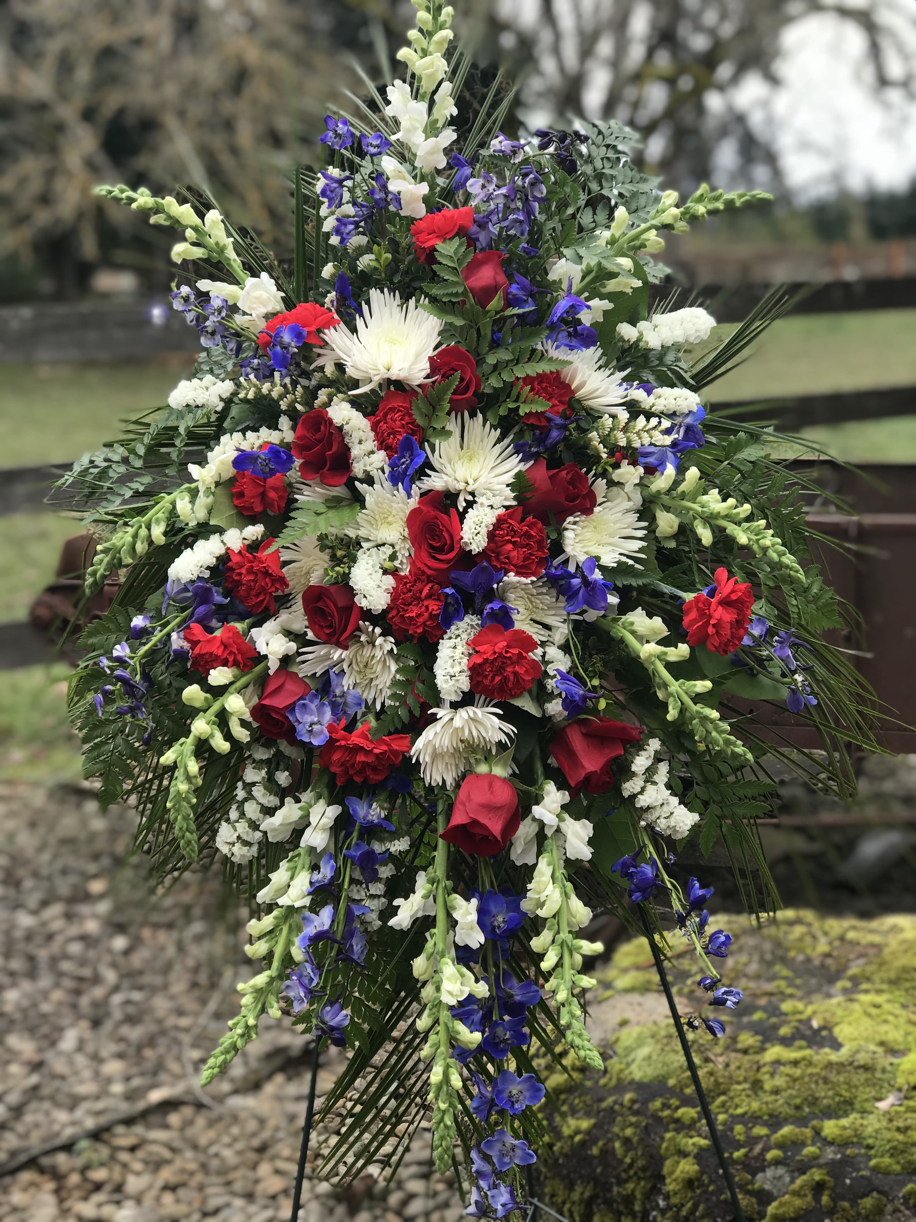 Large standing floral spray with red, white, and blue flowers