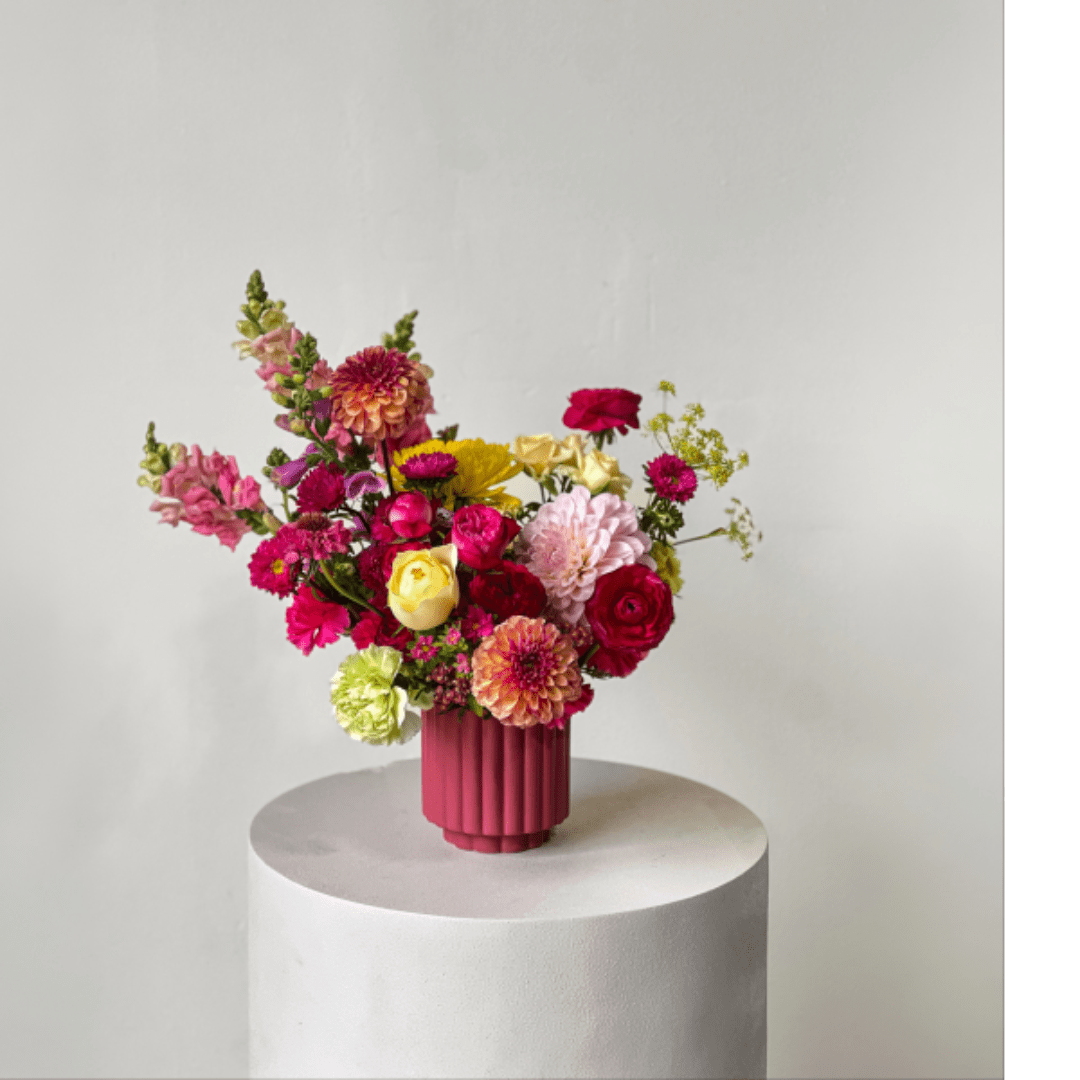 Colorful mixed bouquet in a pink ribbed vase