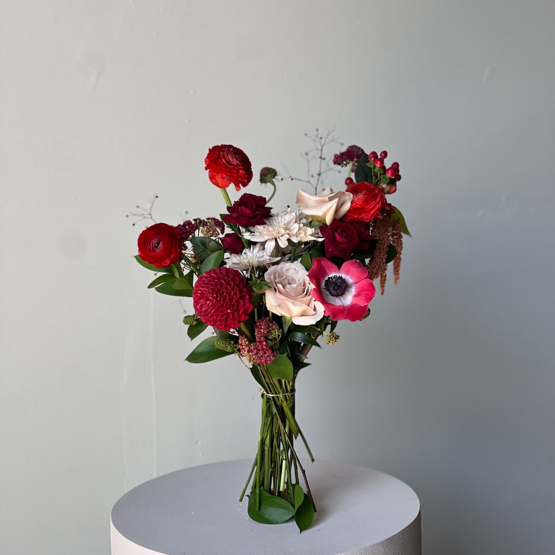 Bouquet of red, pink, and white flowers on a round pedestal