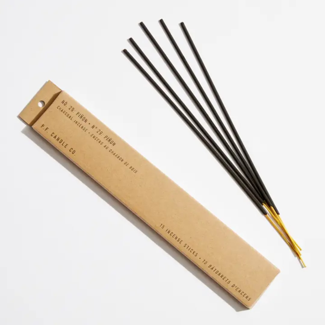 Box of incense sticks beside several loose incense sticks
