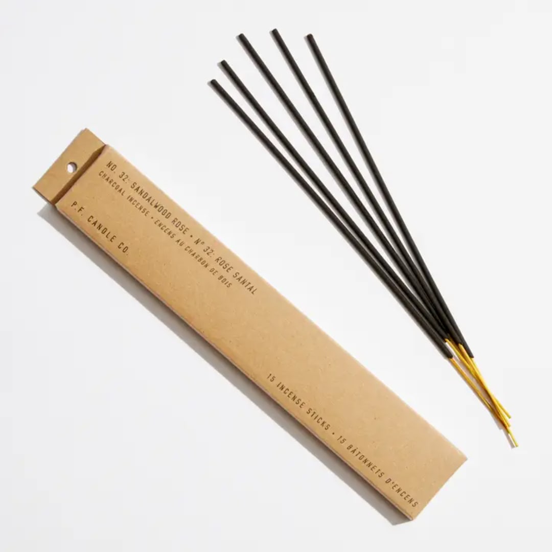 Box of incense sticks beside several loose incense sticks