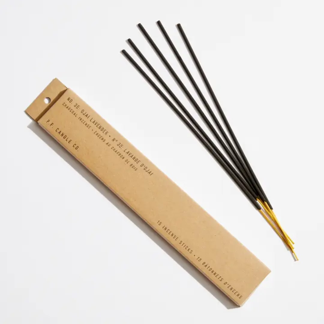 Box of incense sticks beside several loose incense sticks