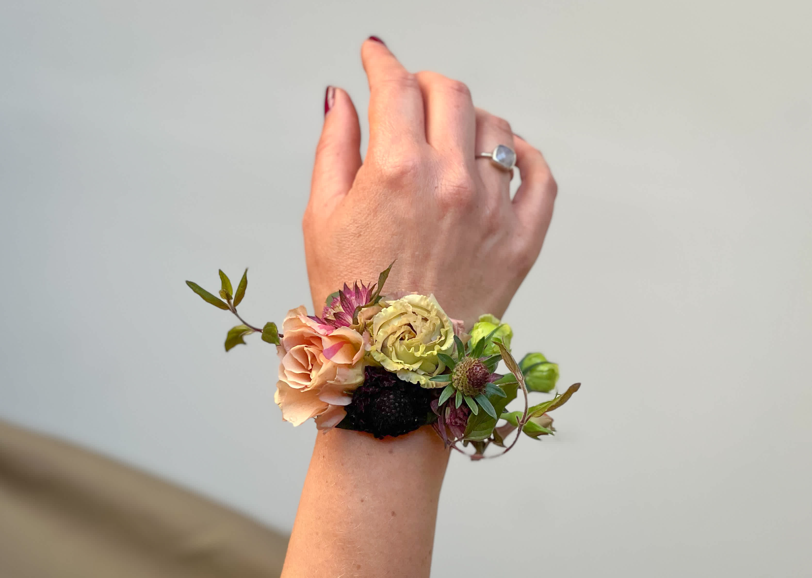 Floral wrist corsage with peach and pale yellow blooms