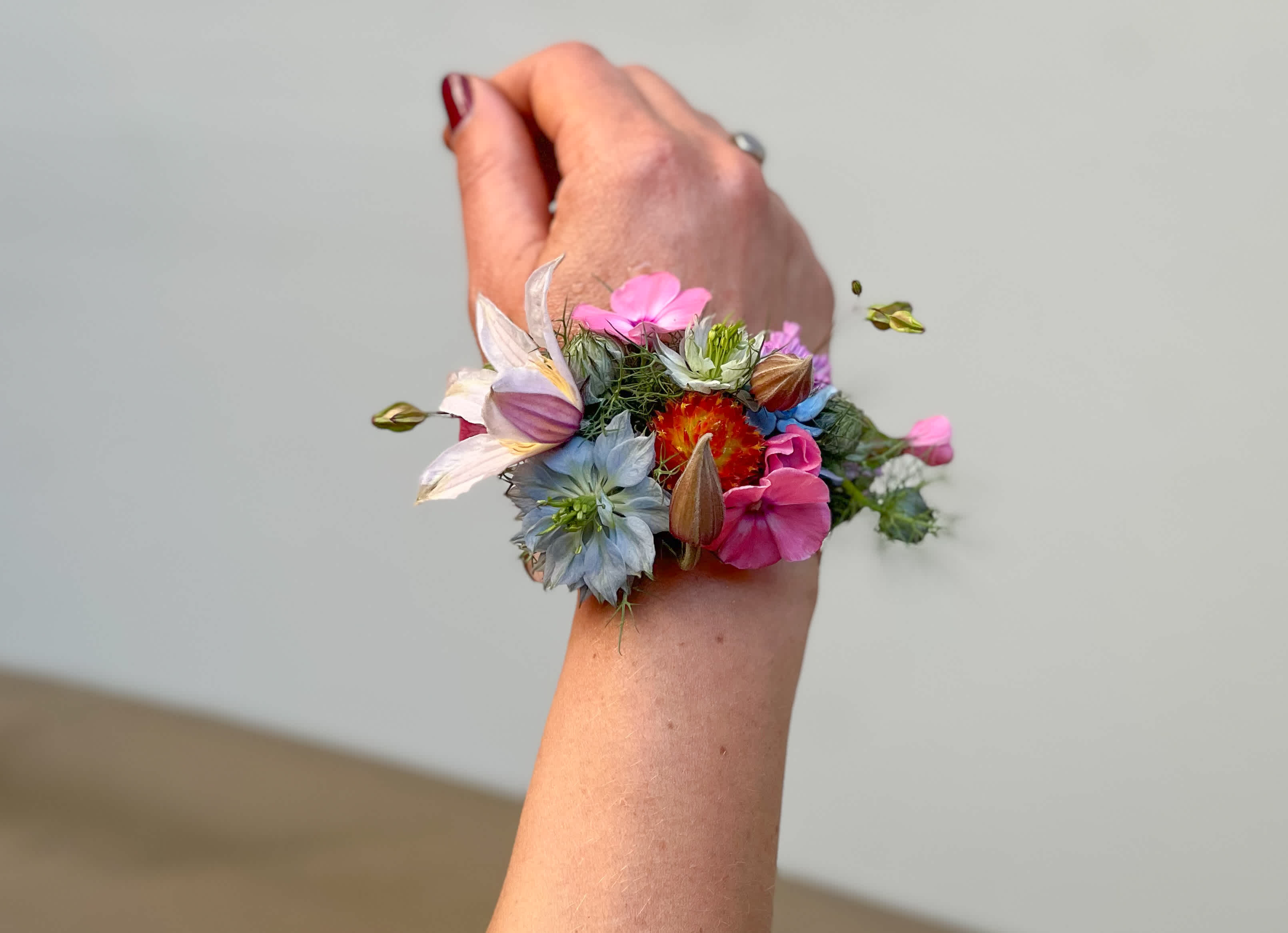 Colorful floral wrist corsage on a person's wrist