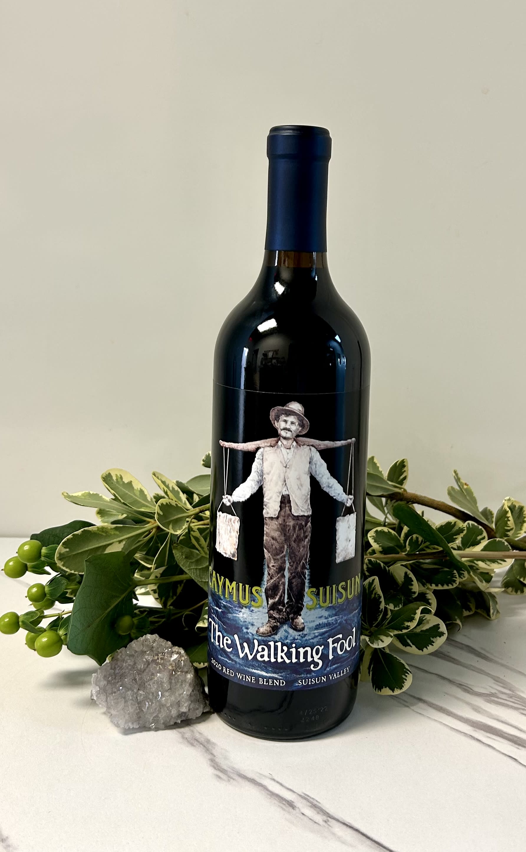 Wine bottle with variegated greenery and a crystal cluster