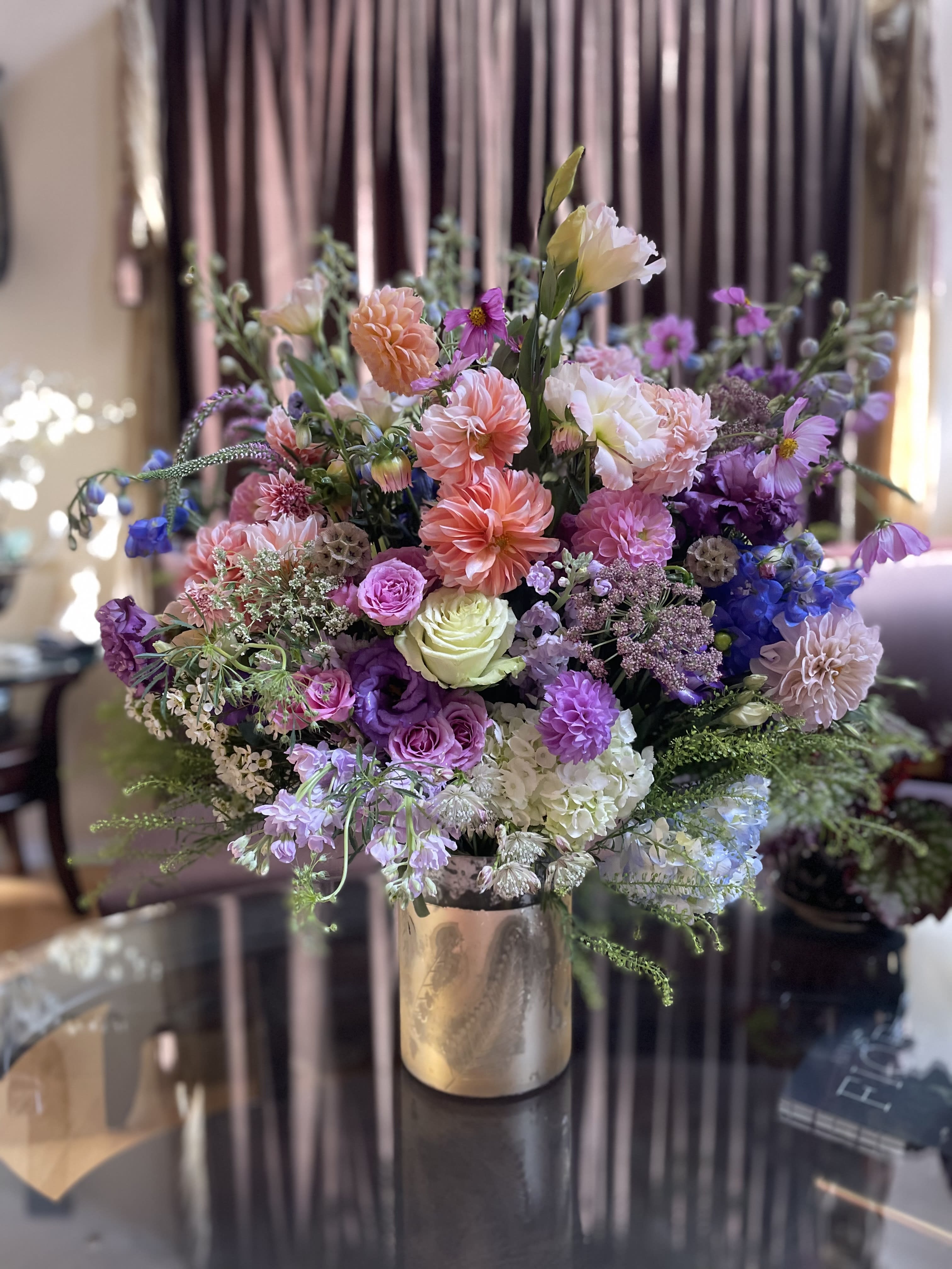 Mixed bouquet of pink, purple, and white flowers in a metallic vase