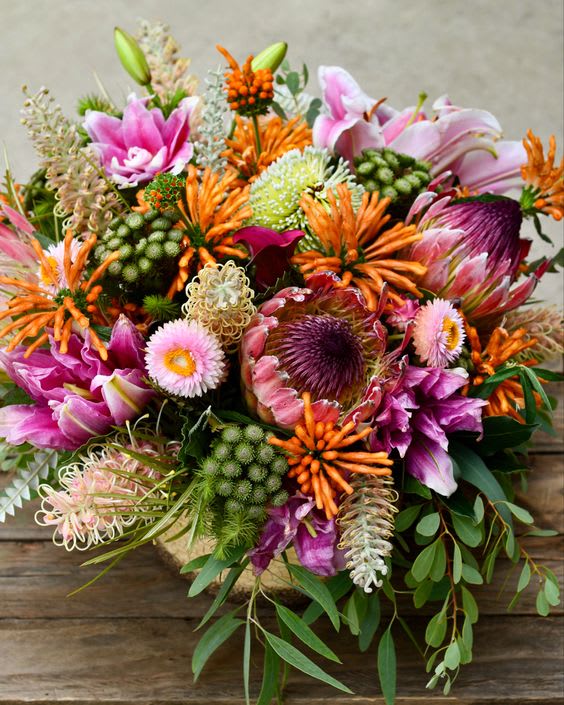Colorful bouquet with pink lilies, orange blooms, and purple flowers