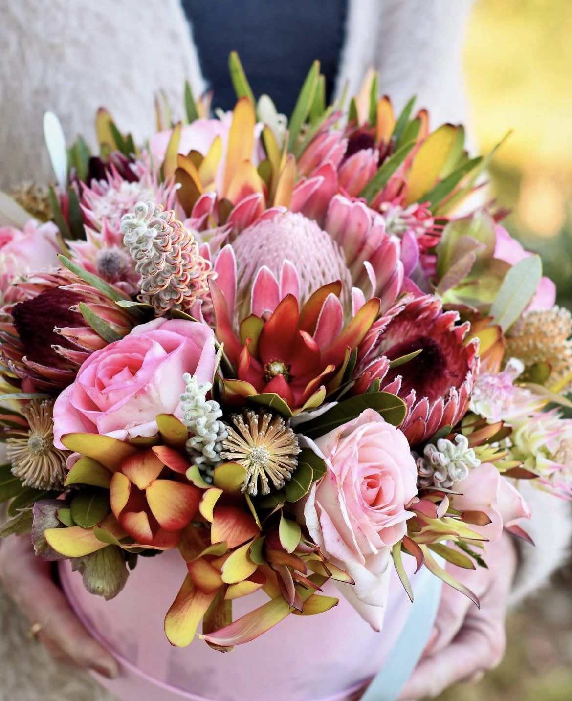 Pink and burgundy bouquet with protea and roses