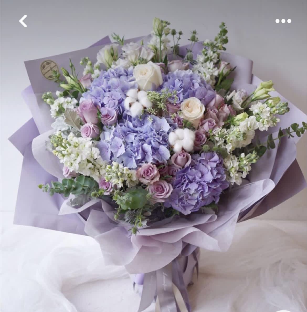 Lavender bouquet with roses and hydrangeas wrapped in lilac paper