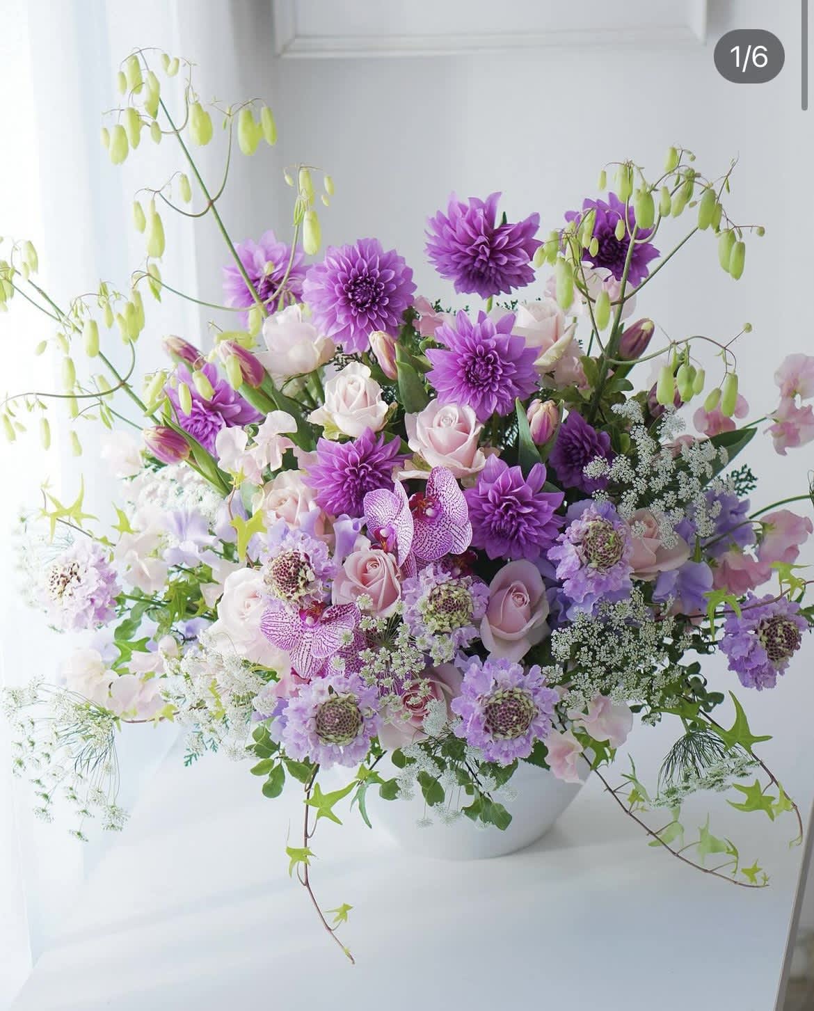 Lavender and pink floral arrangement in a white bowl vase