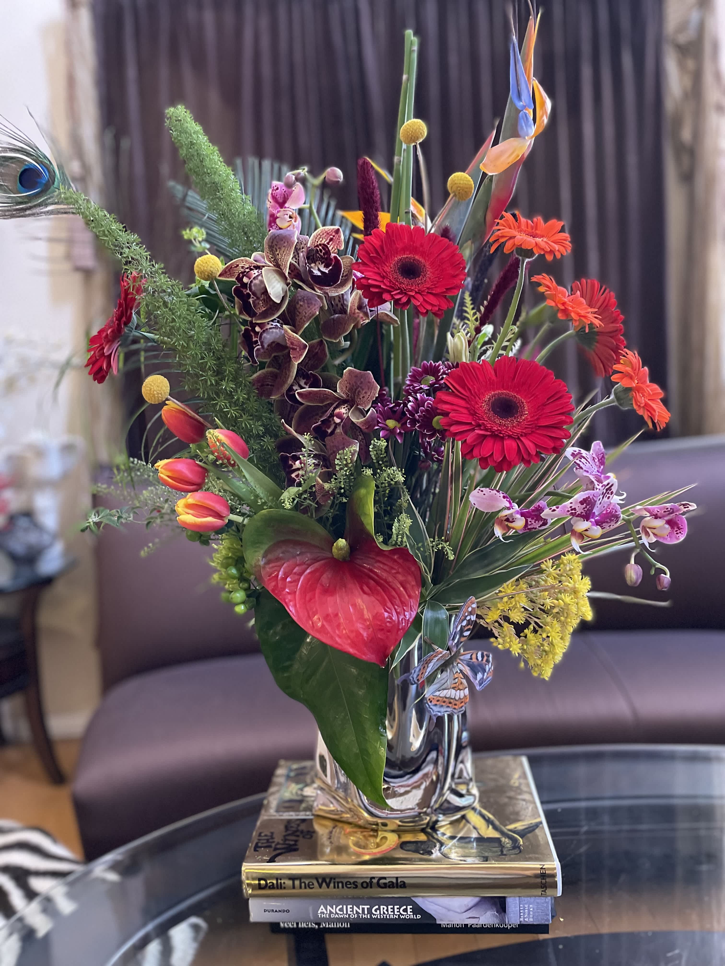 Colorful tropical flower arrangement in a clear glass vase