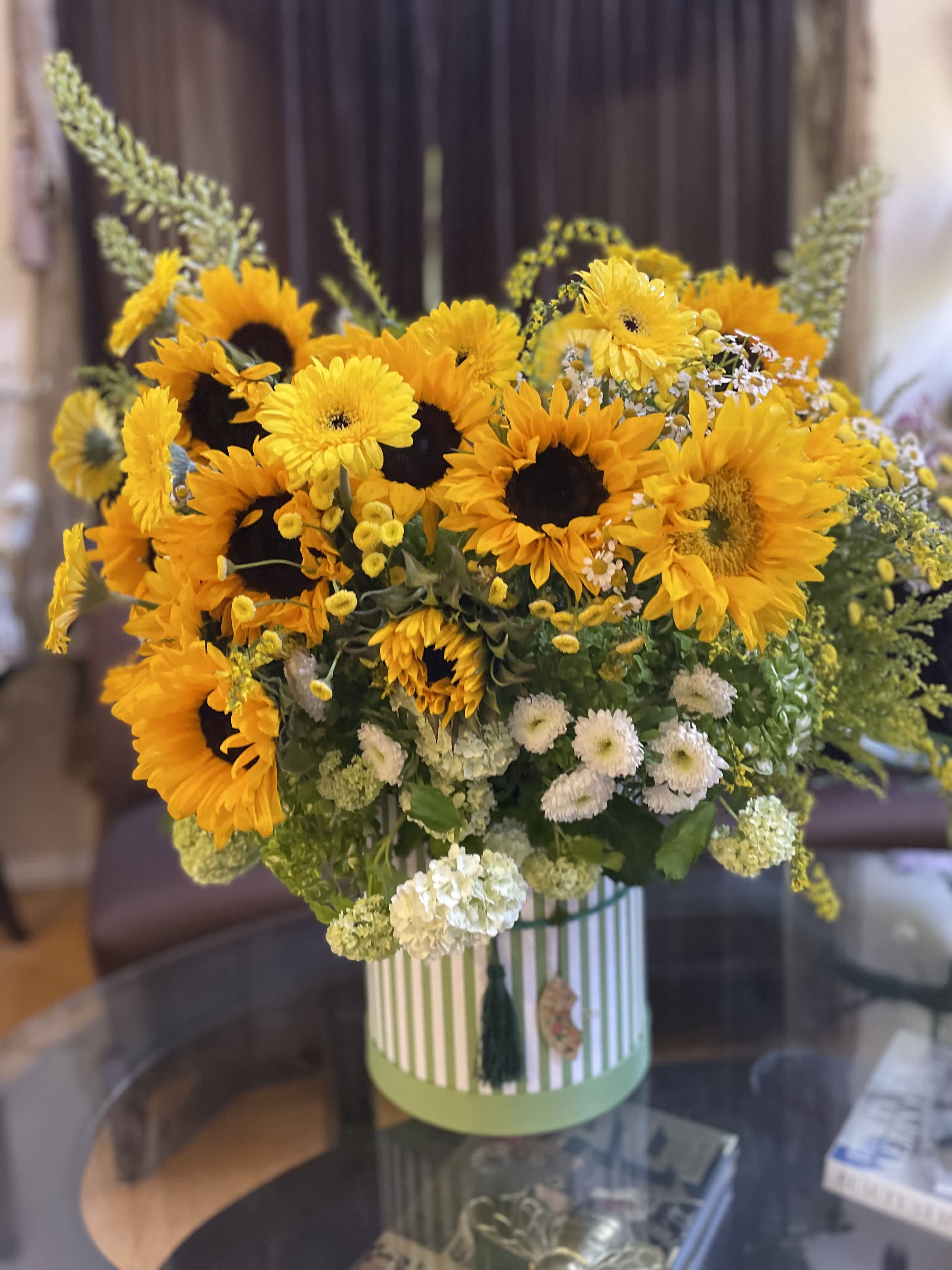 Sunflower bouquet in a striped round box with white accent flowers