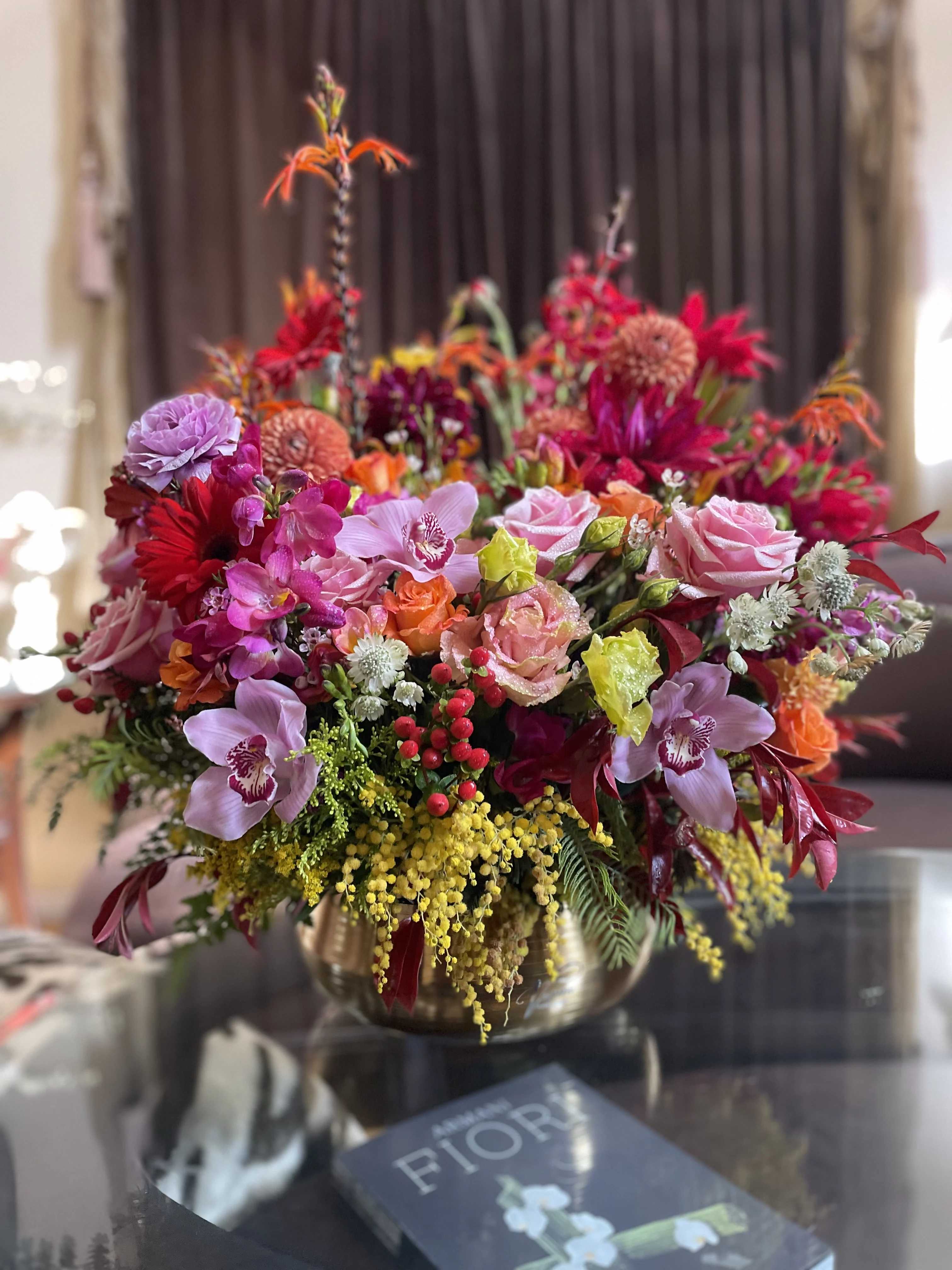 Colorful mixed flower arrangement in a gold vase