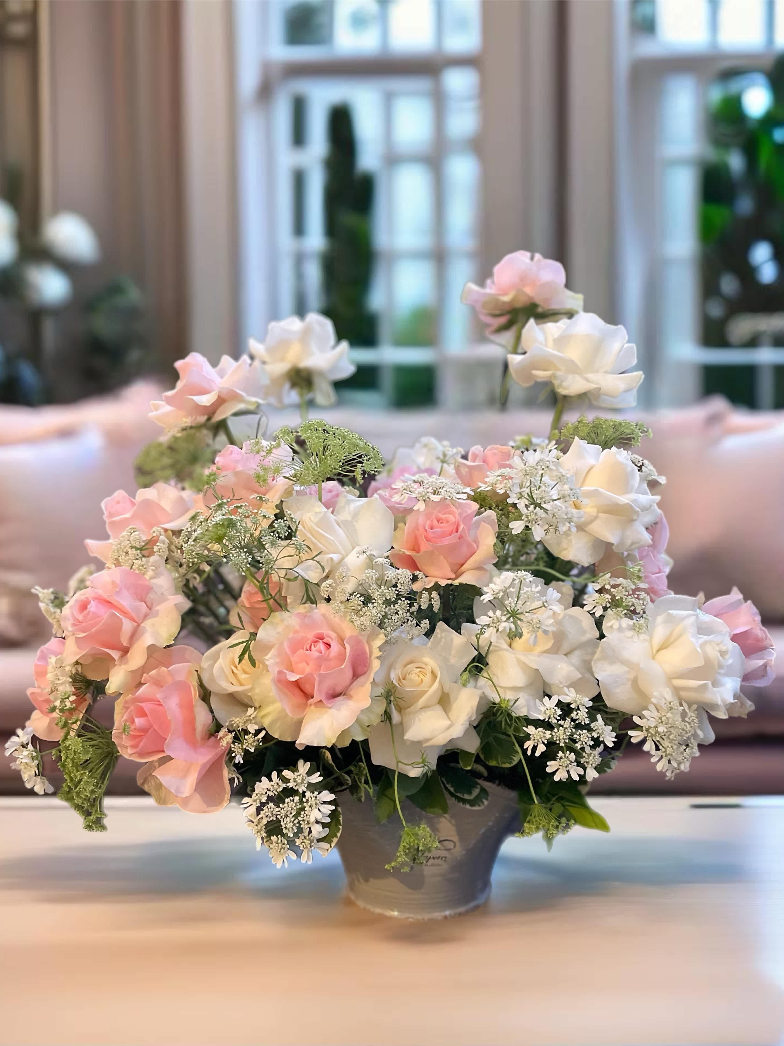 Pink and white roses arranged in a gray vase