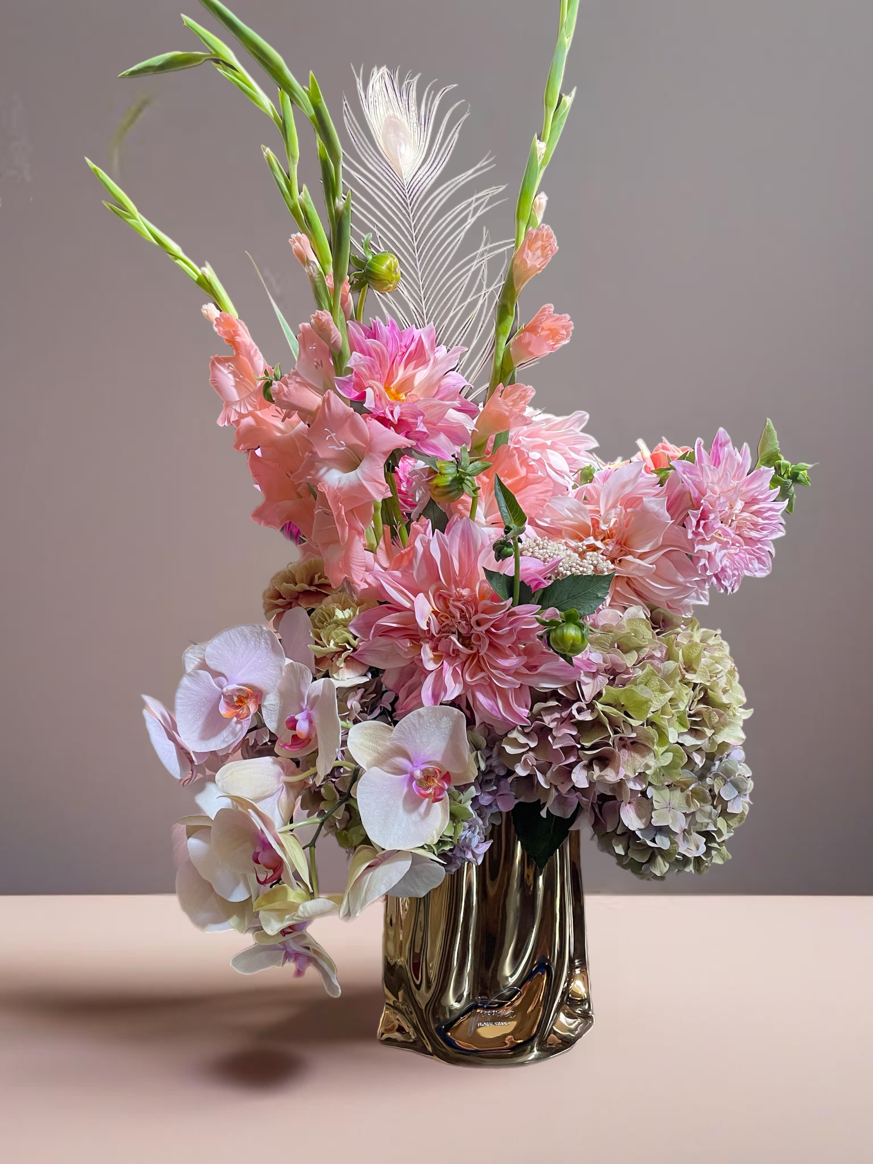 Pink and white floral arrangement in a metallic vase