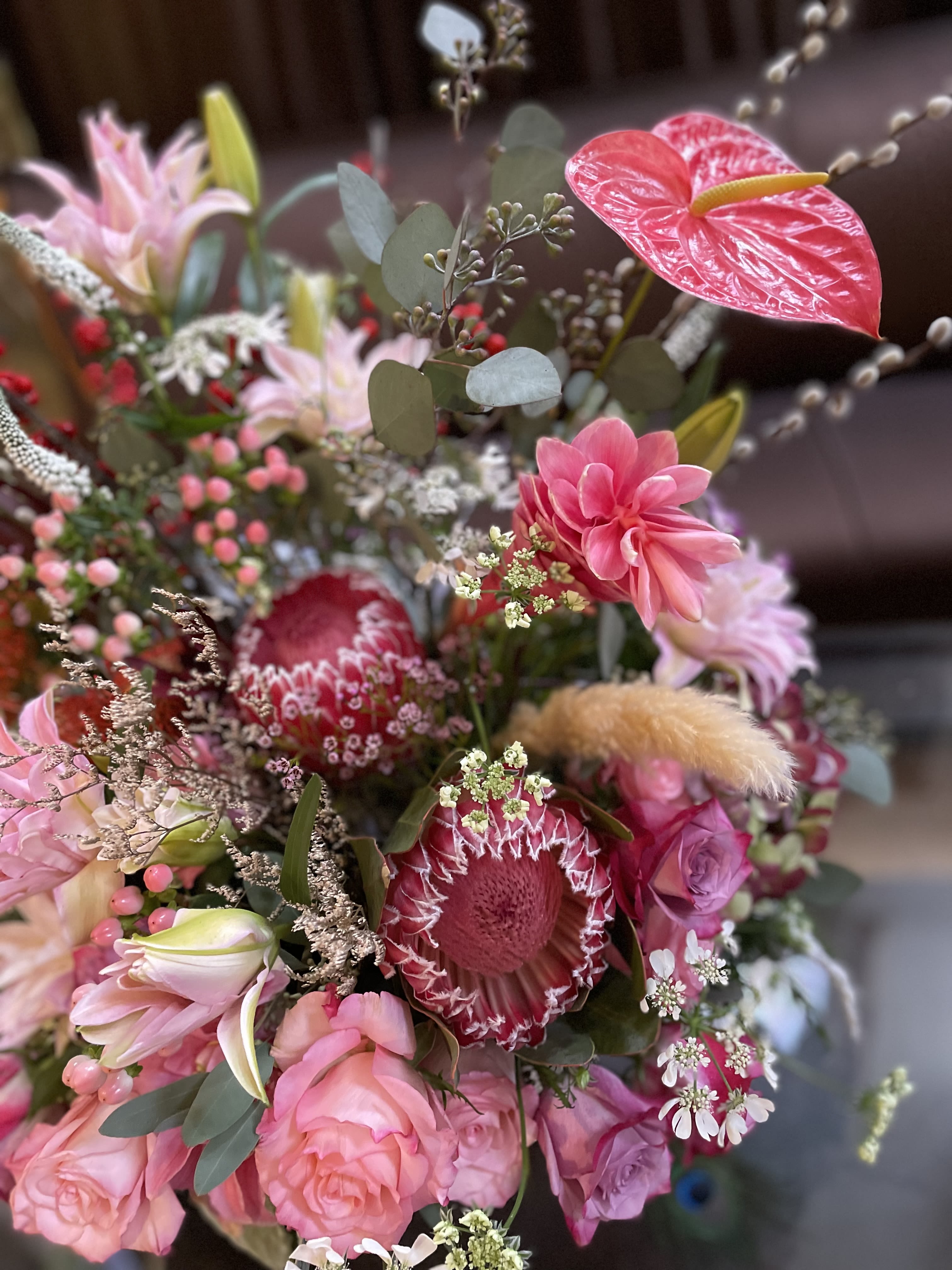 Pink and red mixed bouquet with protea, roses, and lilies