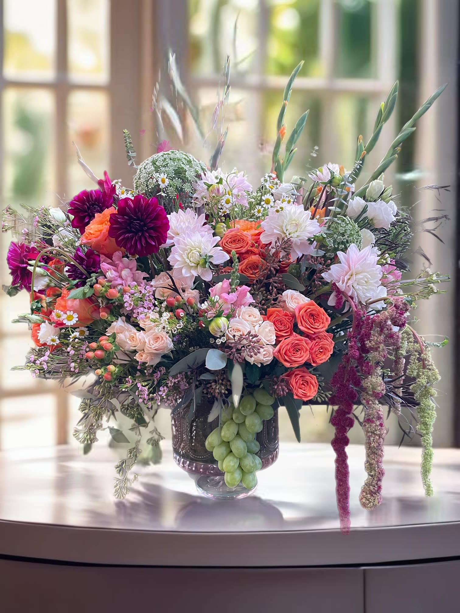 Large mixed bouquet in a glass vase with pink, orange, and white flowers