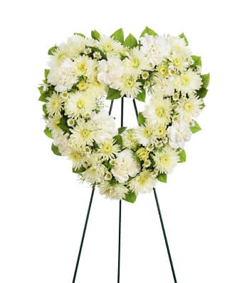 White floral heart-shaped wreath on a stand