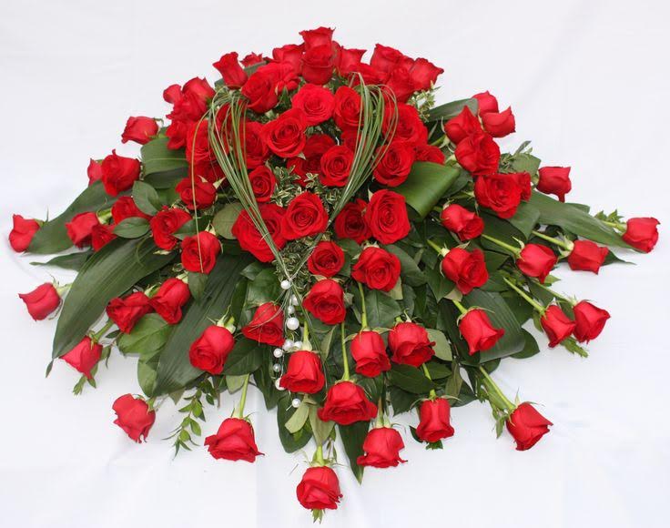 Large bouquet of red roses with greenery on a white background
