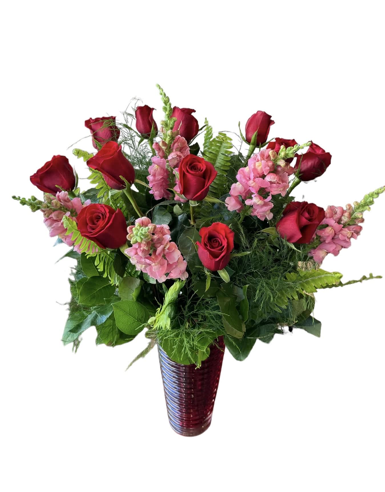 Red roses and pink snapdragons in a tall vase arrangement