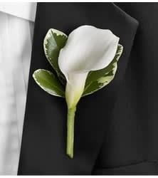 White calla lily boutonniere with green leaves on a black suit lapel