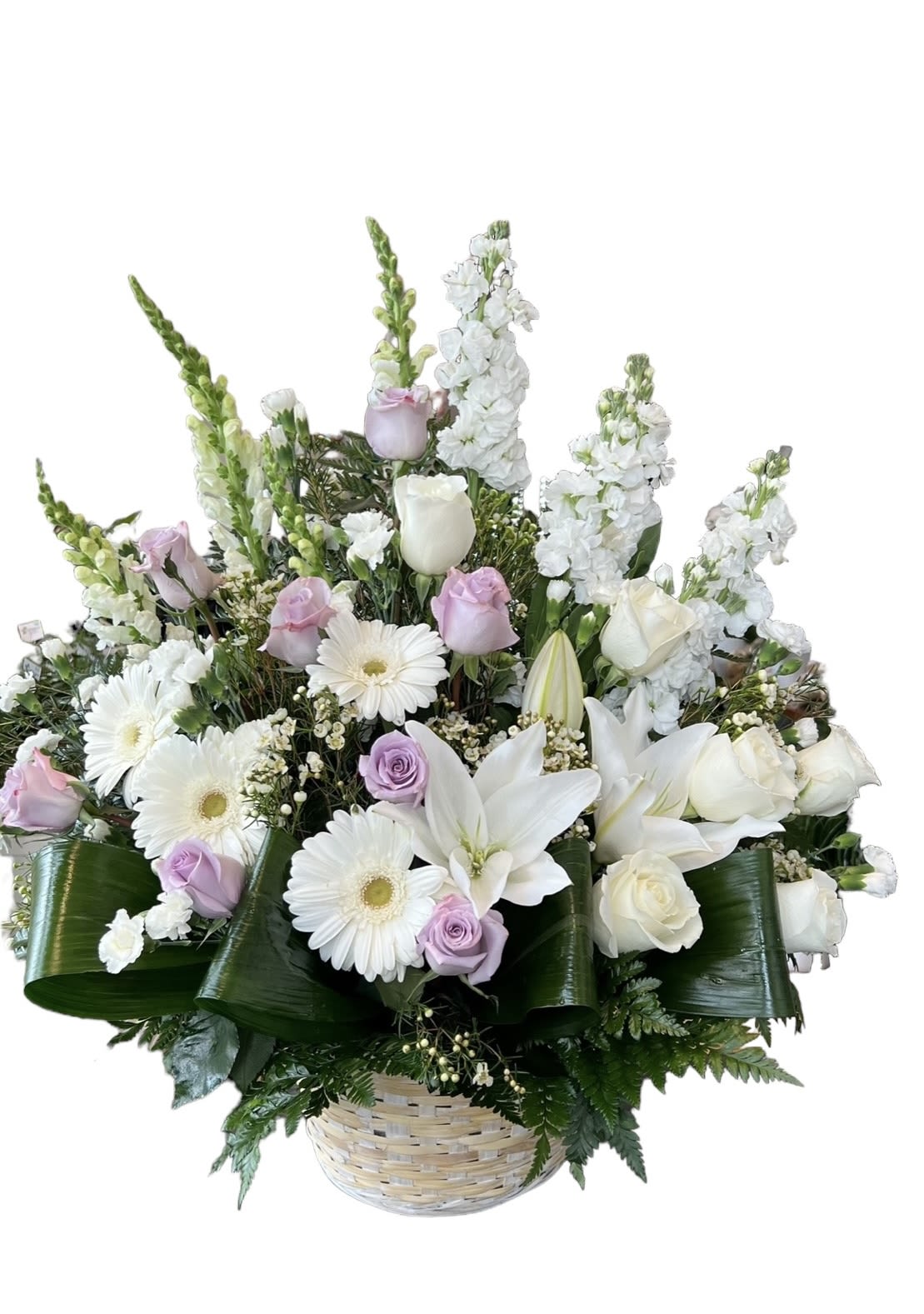 Basket arrangement of white lilies, roses, and daisies with pale lavender roses