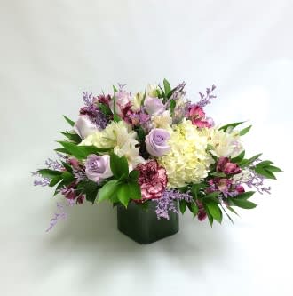 Mixed pastel bouquet in a dark square vase