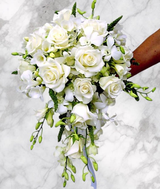 White rose and orchid bridal bouquet with trailing greenery