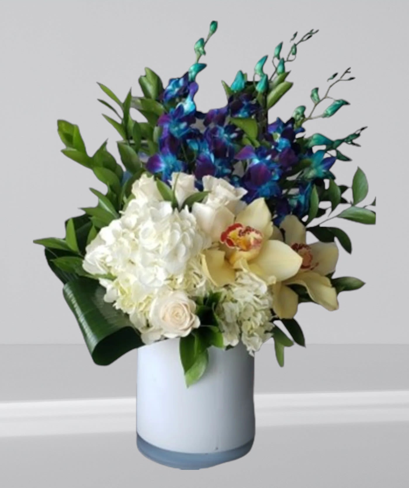 White and blue floral arrangement in a light vase