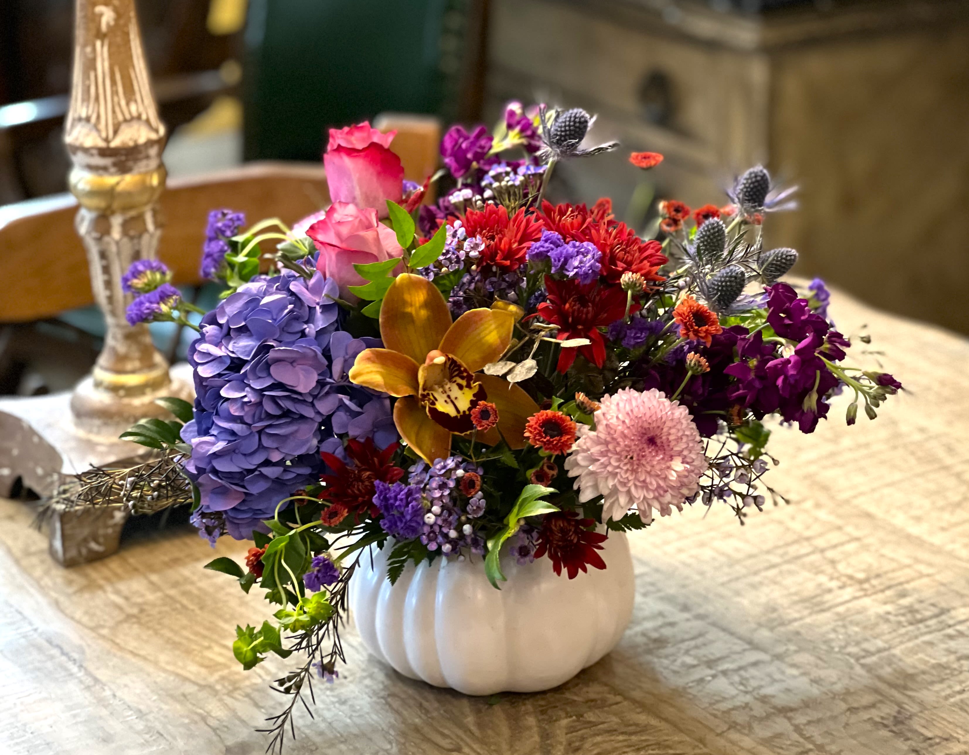 Colorful mixed flower arrangement in a white pumpkin vase