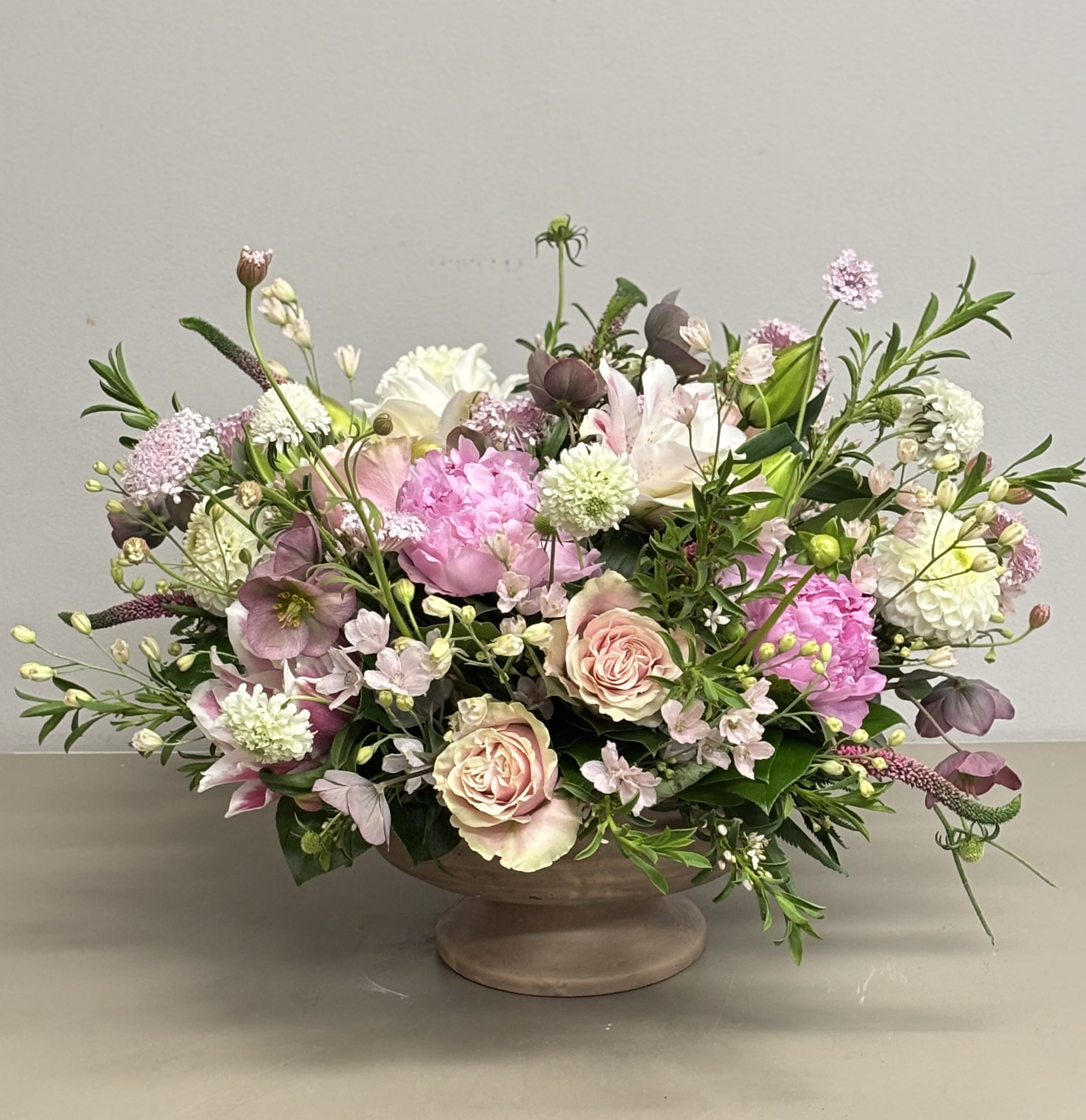 Mixed pink and white floral arrangement in a low pedestal bowl