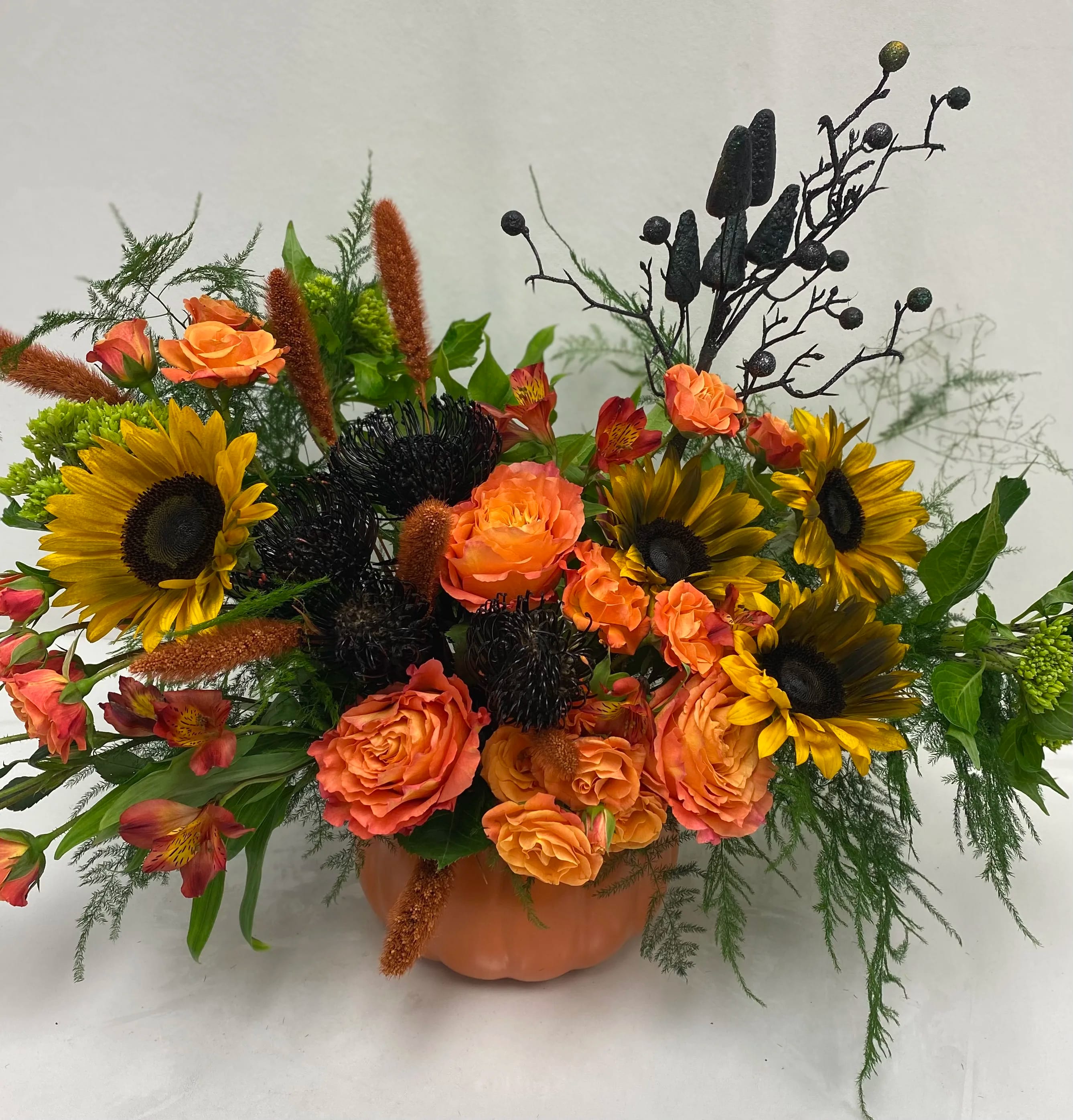 BOO - Halloween arrangement. Ceramic pumpkin vase field with seasonal fall flowers.
