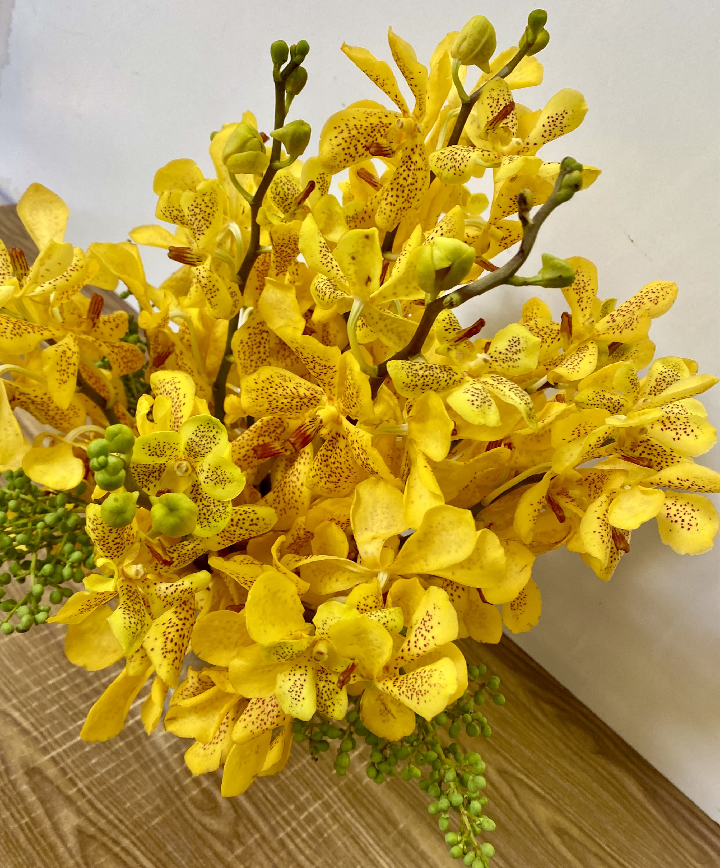 Yellow orchid bouquet with speckled petals and green buds