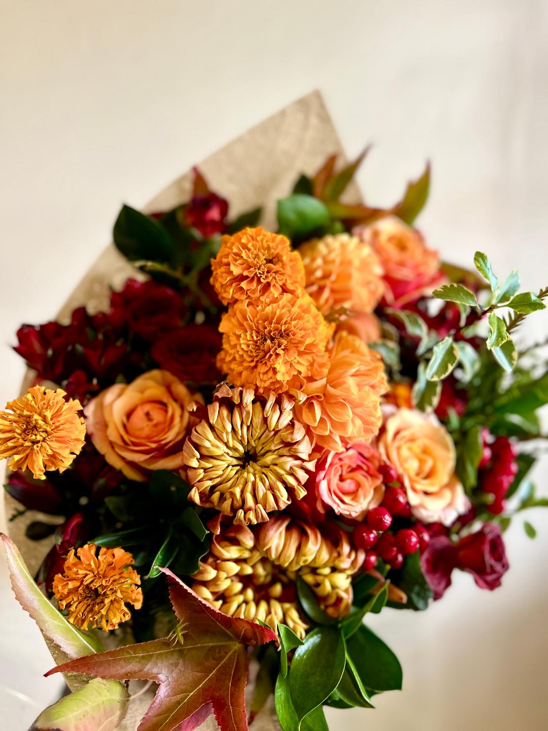 Bouquet of orange and red flowers wrapped in paper