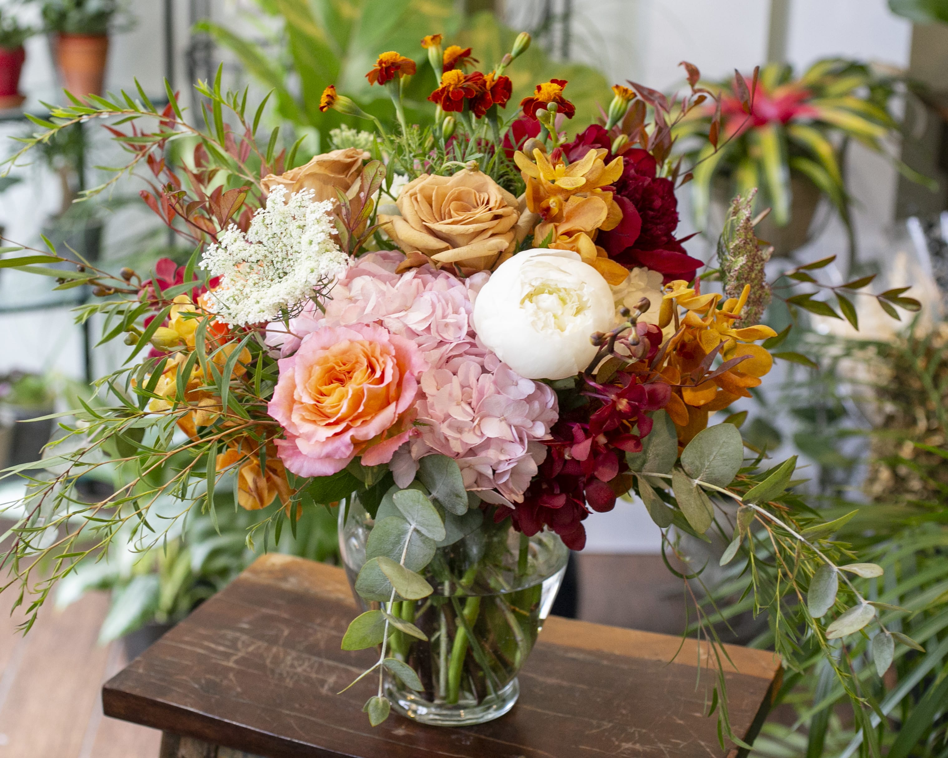 Marisel - Warm autumn colors and interesting textures arranged in a clear glass vase.