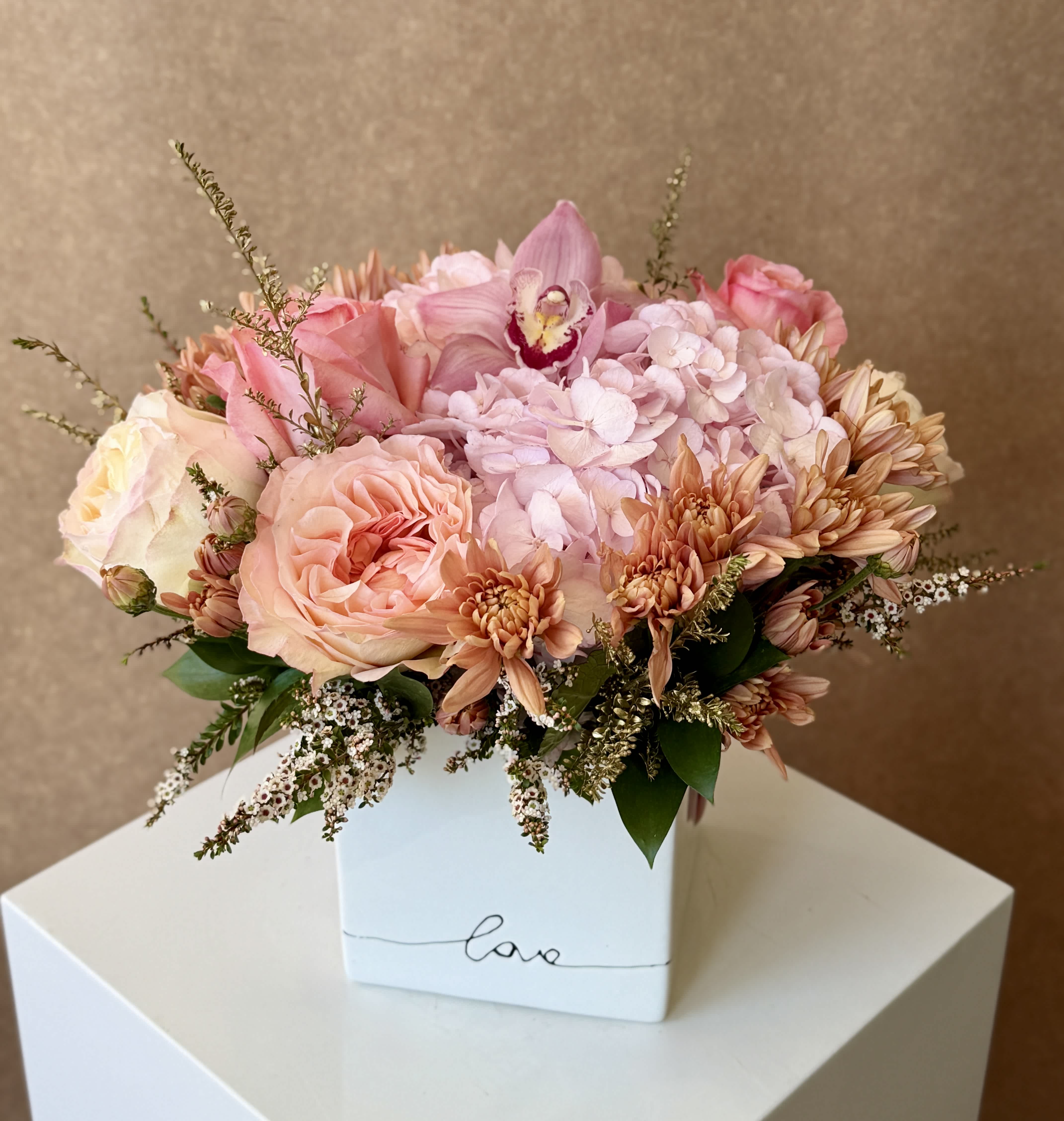 Pink and peach bouquet in a white box vase