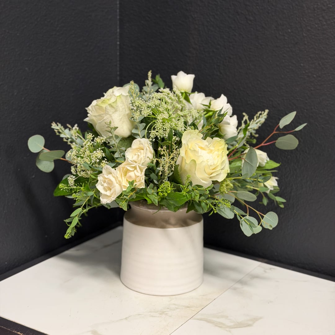 White rose bouquet in a cream ceramic vase
