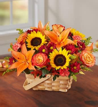 Basket arrangement with sunflowers, orange lilies, and roses