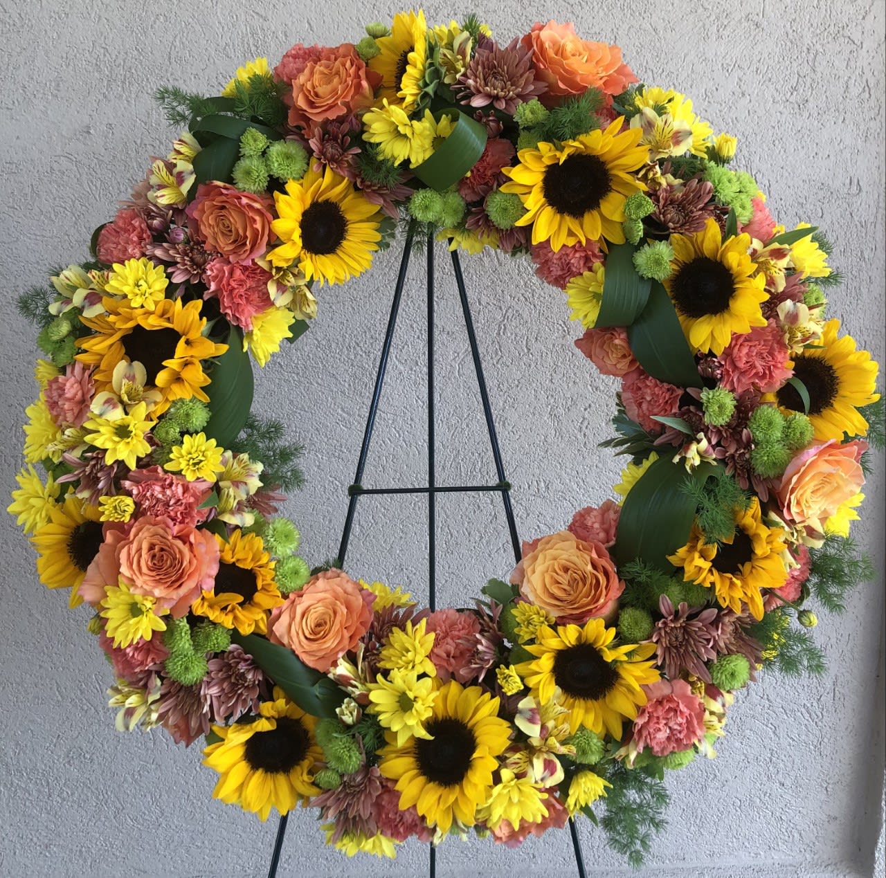 Sunflowers, mums, roses, carnations and greenery - Colorful wreath to add some sunshine and happiness to the occasion.