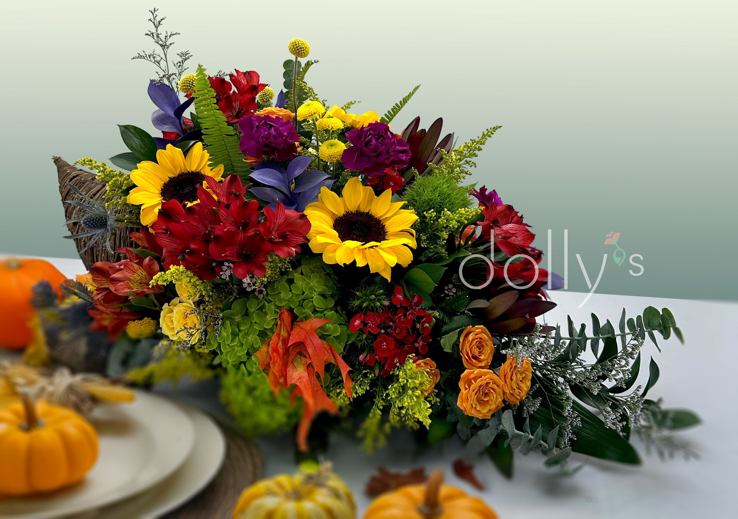 Colorful autumn floral arrangement with sunflowers and red blooms in a basket