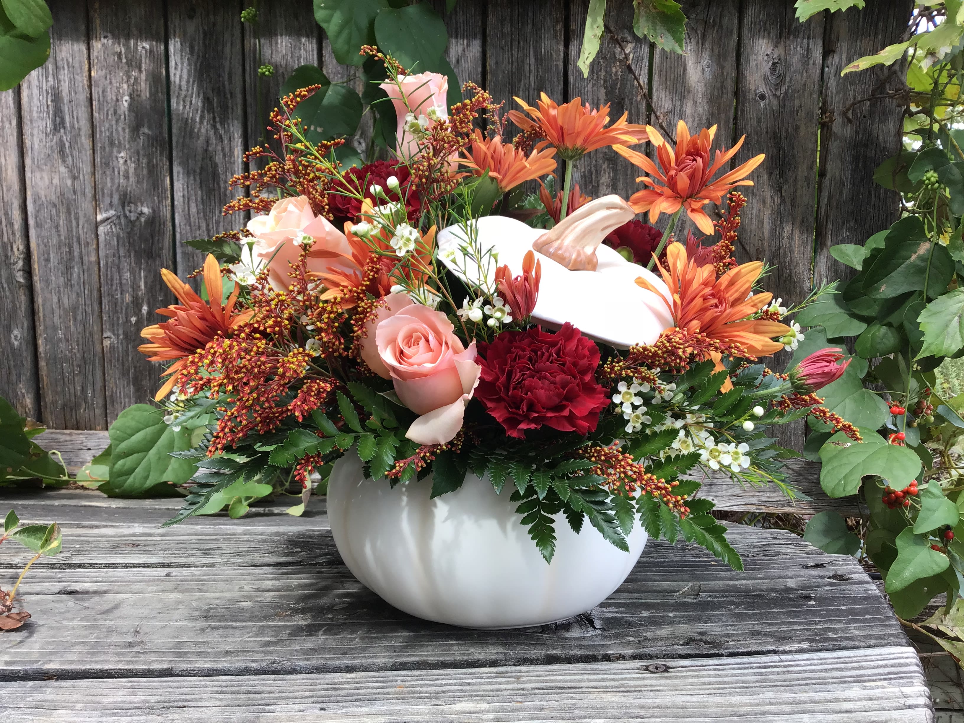 Pumpkin-shaped vase with orange and pink flowers