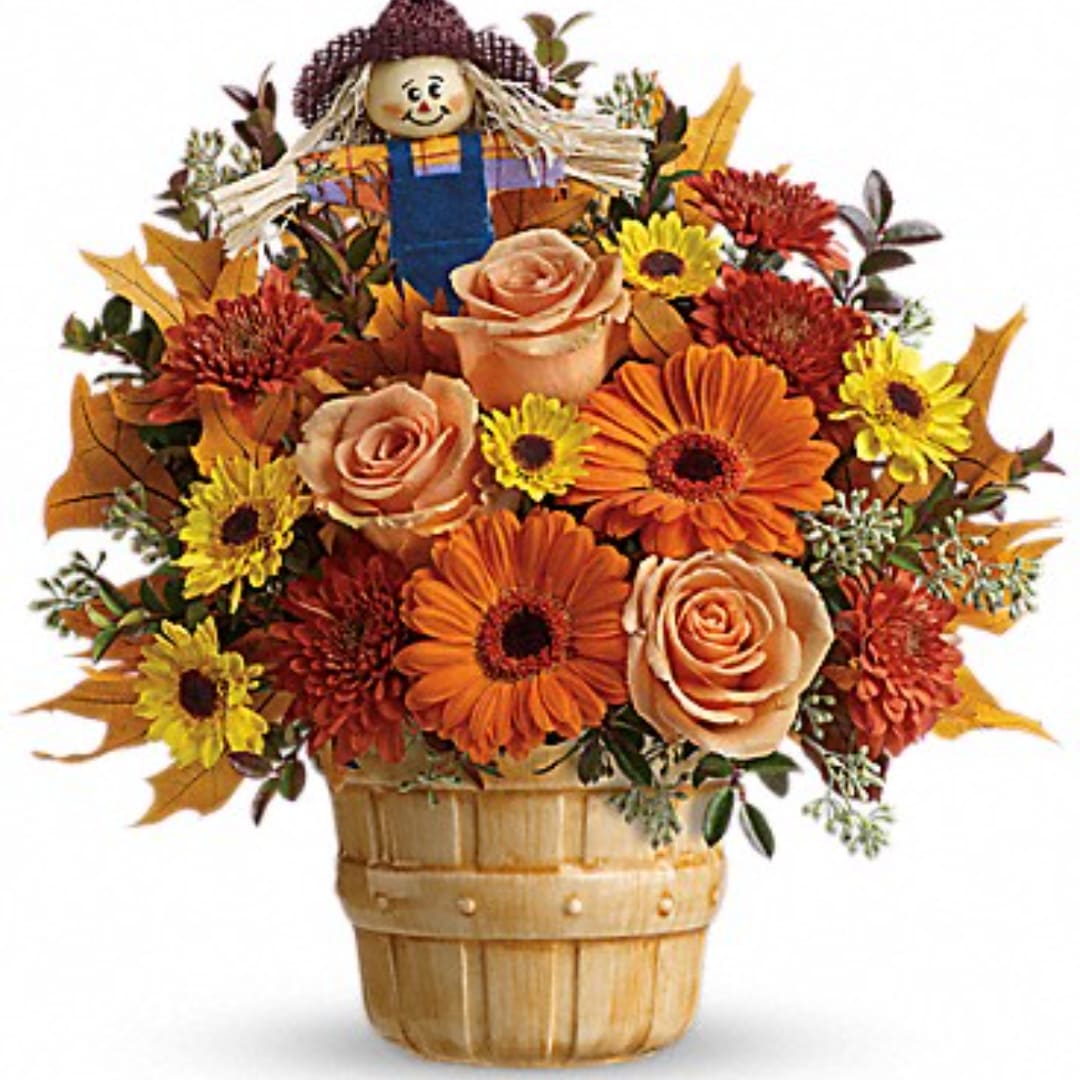 Autumn flower basket with roses, daisies, and a scarecrow topper