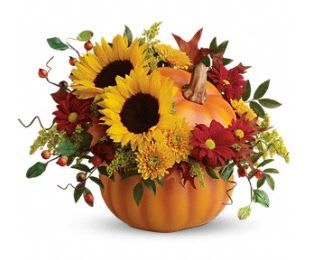 Sunflowers and autumn flowers arranged in a pumpkin container