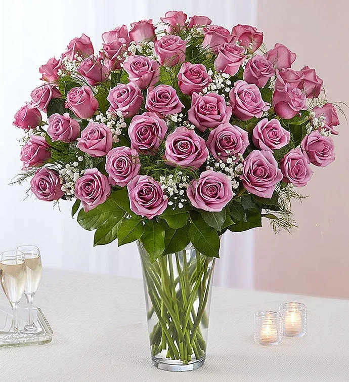 Pink roses arranged in a clear glass vase with baby's breath