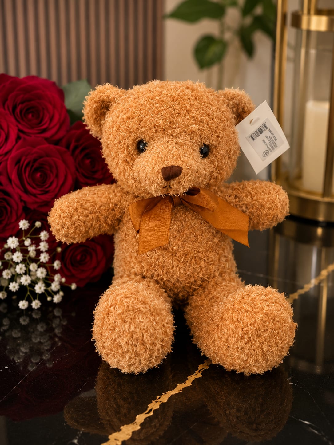 Teddy bear beside red roses and small white flowers