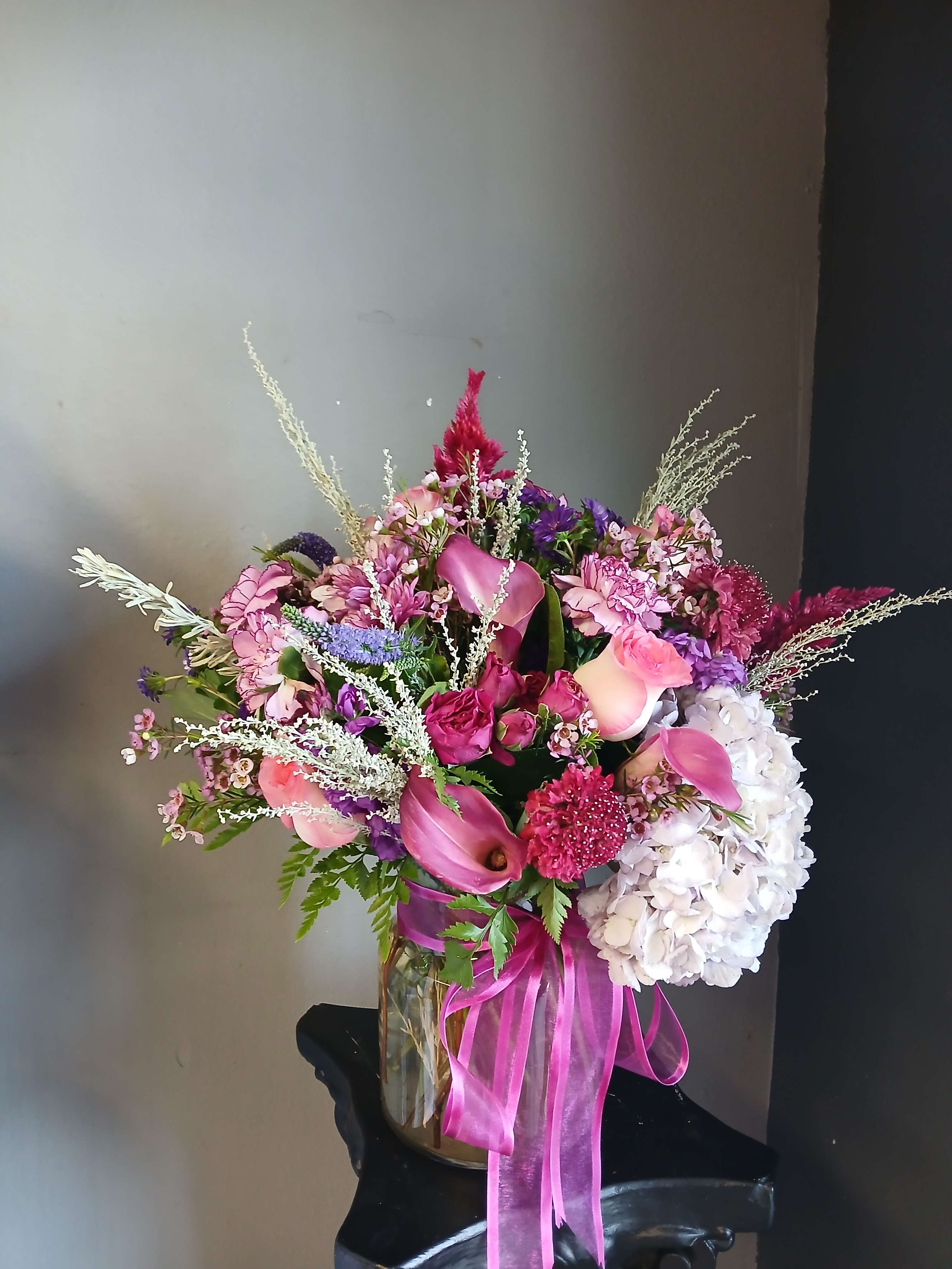 Pink and purple mixed bouquet in a glass vase with a ribbon